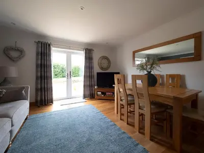 a living room with a wooden table and a mirror at East Laigh Gree Bed and Breakfast in Burnhouse