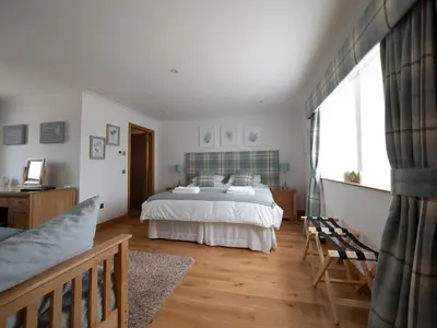 a bedroom with a bed and a large window at East Laigh Gree Bed and Breakfast in Burnhouse