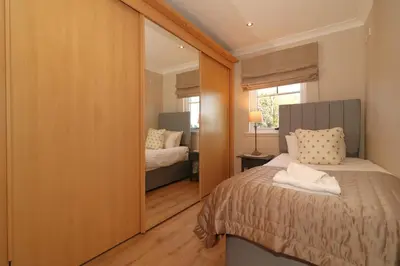 a bedroom with a bed and a mirror at Signature - Cross House in Lanark