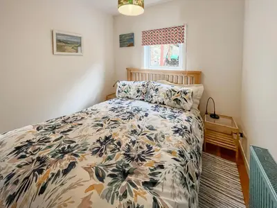 a bedroom with a bed with a floral bedspread at Ardtornish Apartment in Tayvallich
