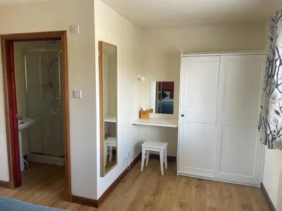 a room with a white closet and a chair in it at The Roost in Appin