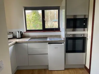 a kitchen with white appliances and a window in it at The Roost in Appin