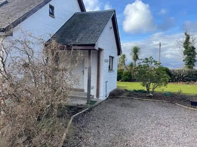 a small white house with a porch and a driveway at The Roost in Appin