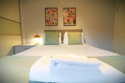 a bedroom with a white bed with towels on it at Signature - Drumvale House in Chryston