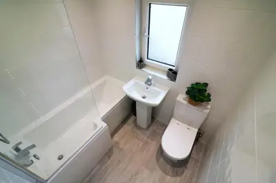 a white bathroom with a toilet and a sink at Signature - Drumvale House in Chryston
