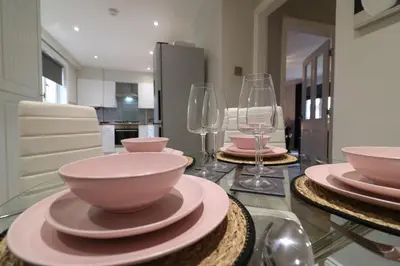 a dining table with bowls and plates and wine glasses at Signature - Drumvale House in Chryston