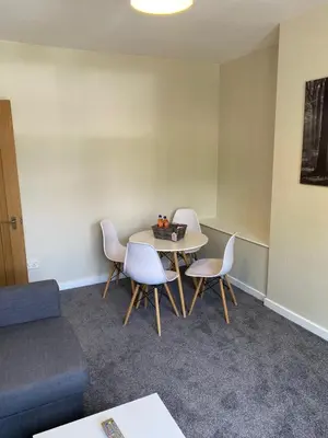 a room with a table and chairs and a couch at Glen Mhor - Beautiful two bedroom apartment Dunfermline in Townhill