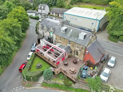 an aerial view of a large house with cars parked at Gordon Arms Hotel in West Linton