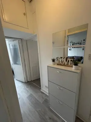 a room with a dresser with a mirror and a door at Bright bedroom with king side bed and share bathroom in Edinburgh
