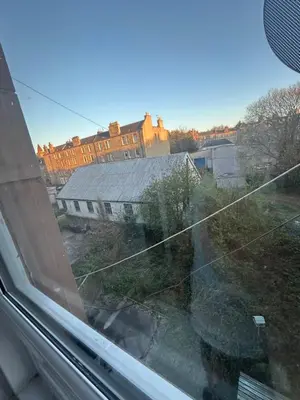a view of a building from the window of a train at Bright bedroom with king side bed and share bathroom in Edinburgh