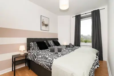 a bedroom with a large bed and a window at Vacant Nests The Milton Dunfermline Parking in Dunfermline