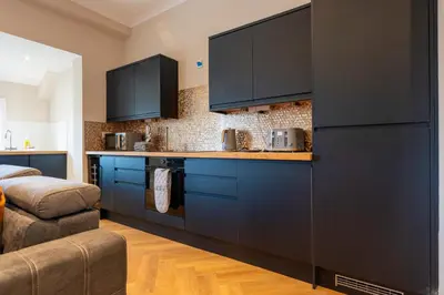 a kitchen with blue cabinets and a counter top at Station Road Stays in Hartwood