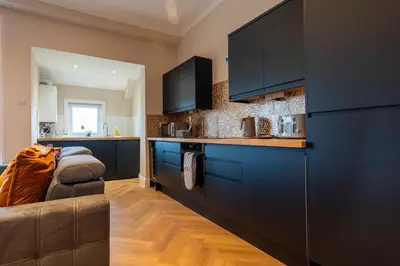 a kitchen with blue cabinets and a couch in a room at Station Road Stays in Hartwood