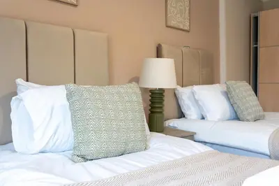 a bedroom with two beds and a lamp in it at Station Road Stays in Hartwood