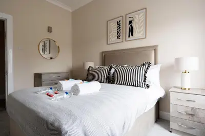 a bedroom with a large bed with two towels on it at Station Road Stays in Hartwood