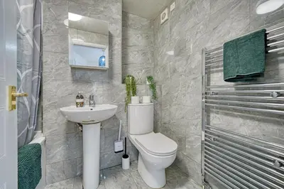 a bathroom with a toilet and a sink and a shower at 2BR Flat with Free Parking in Central Location in Glasgow