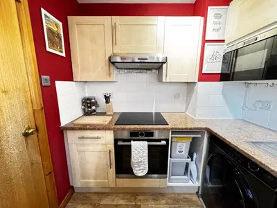 a kitchen with a stove top oven next to a dishwasher at The Maltings Retreat in Inverkeithing