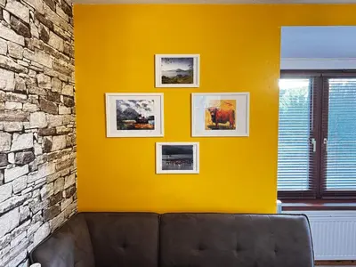 a yellow wall with a couch in a room at The Maltings Retreat in Inverkeithing