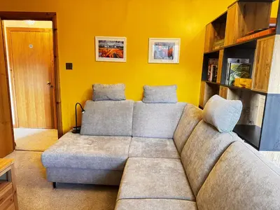 a living room with a couch and a yellow wall at The Maltings Retreat in Inverkeithing