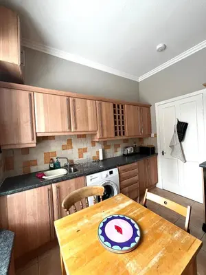 a kitchen with a wooden table with a plate on it at Two Bedroom Apartment in Bridge of Allan in Bridge of Allan
