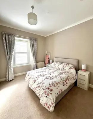 a bedroom with a bed and a window at Two Bedroom Apartment in Bridge of Allan in Bridge of Allan