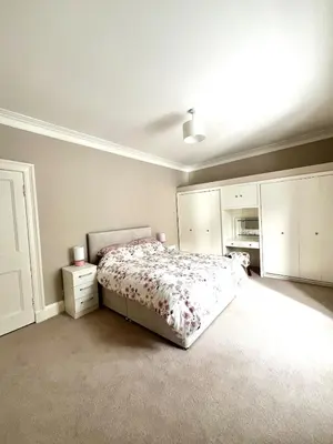 a bedroom with a bed and white cabinets at Two Bedroom Apartment in Bridge of Allan in Bridge of Allan