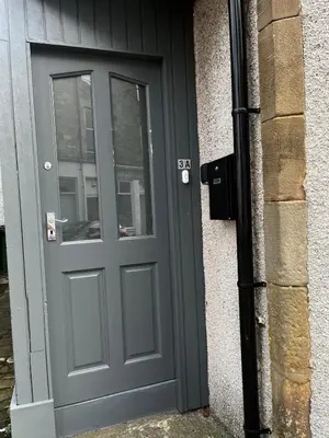 a gray door on the side of a building at Two Bedroom Apartment in Bridge of Allan in Bridge of Allan