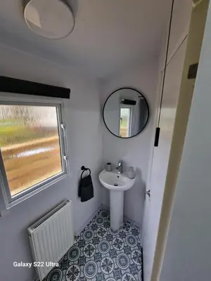 a small bathroom with a sink and a mirror at Forest Valley Holiday Home in Ballantrae