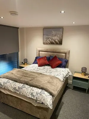 a bedroom with a large bed with red and blue pillows at SEC Hydro Duplex in Finnieston in Glasgow