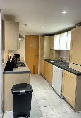 a kitchen with wooden cabinets and a counter top at SEC Hydro Duplex in Finnieston in Glasgow