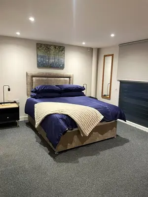 a bedroom with a large bed with blue pillows at SEC Hydro Duplex in Finnieston in Glasgow