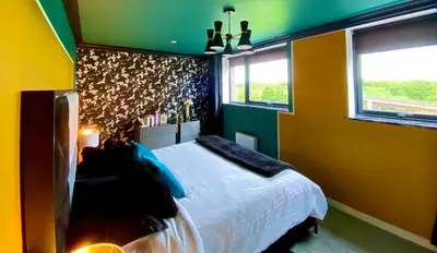 a bedroom with a white bed and green walls at Private Bedroom & Bathroom with Amazing View in Quirky Townhouse in Glasgow