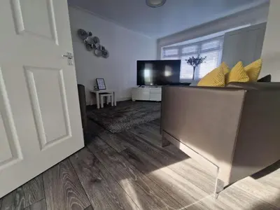 a living room with a couch and a television at Cozy Shotts House with 2 Bedrooms in Kirk of Shotts