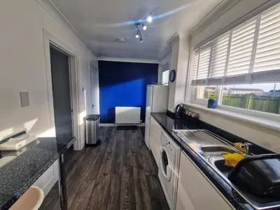 a kitchen with a sink and a refrigerator at Cozy Shotts House with 2 Bedrooms in Kirk of Shotts