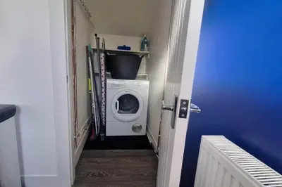 a laundry room with a washing machine in a hallway at Cozy Shotts House with 2 Bedrooms in Kirk of Shotts