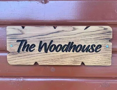 a wooden sign that reads the wood house at The Woodhouse Cabin 8 in Moffat