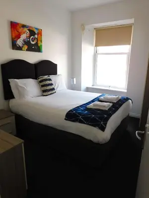a large bed in a bedroom with a window at No 1 - 2 bedroom apartment in Lanark Town Centre in Lanark