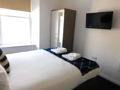 a hotel room with a bed and a flat screen tv at No 1 - 2 bedroom apartment in Lanark Town Centre in Lanark