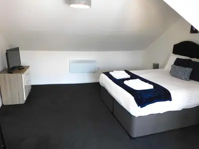 a bedroom with a bed and a television in it at No 7 - Modern 1 Bedroom Apartment in Lanark Town Centre in Lanark