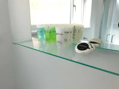a glass counter in a bathroom with some products on it at No 7 - Modern 1 Bedroom Apartment in Lanark Town Centre in Lanark