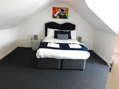 a bedroom with a large bed in a attic at No 7 - Modern 1 Bedroom Apartment in Lanark Town Centre in Lanark