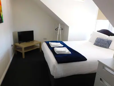 a hotel room with a bed and a television at No 11 - Contemporary 2 Bedroom Apartment in Lanark Town Centre in Lanark