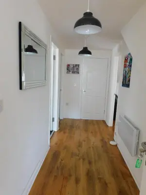 a hallway with white walls and a hard wood floor at No 11 - Contemporary 2 Bedroom Apartment in Lanark Town Centre in Lanark