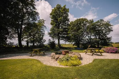two picnic tables and rocks in a park at Stunning Barn Conversion in Dunlop