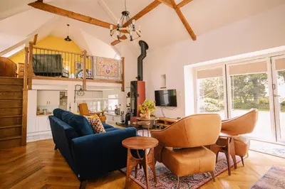 a living room with a blue couch and a table at Stunning Barn Conversion in Dunlop