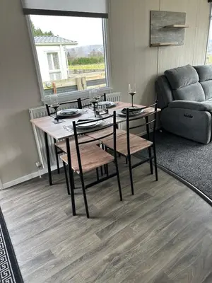 a living room with a table and chairs and a couch at Swift Bordeaux Sea View 10 in Ardentinny