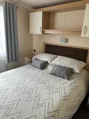 a bedroom with a large bed with two pillows at Swift Serenity 50 in Ardentinny