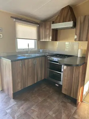 a kitchen with wooden cabinets and a sink and a stove at Winchester 23 in Ardentinny