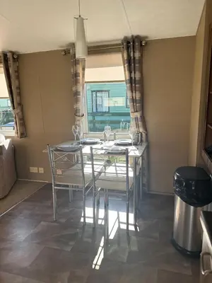 a dining room with a table with chairs and a window at Winchester 23 in Ardentinny
