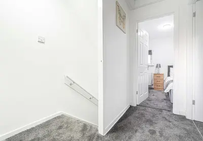 a white room with a hallway with a mirror at Pure Home Oakley Park View by TBA in Dunfermline